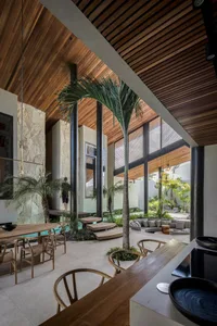 Modern residential patio featuring a combination of wood and concrete materials, with a dining area and lounge seating.