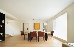 A minimalist interior with a wooden dining table and chairs.