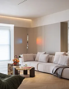 A modern living room featuring comfortable cushions against a wooden wall and a wooden floor, with ambient lighting and a sma