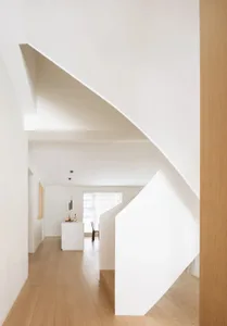 Modern minimalist floating staircase with white concrete treads and oak wood flooring in a residential hallway