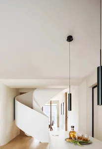 A minimalist interior featuring a white concrete spiral staircase