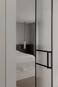 A minimalist bathroom featuring a glass-pane wall and floor, viewed from the doorway.