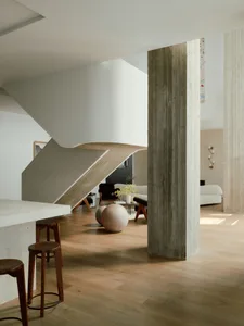 Contemporary living room with concrete, wooden, and metallic architectural features.