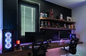 A well-lit, modern industrial home office with dark walls and a large desk.