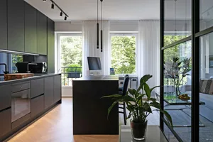 Modern kitchen featuring metallic cabinets and glass elements.