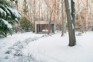 現代簡約度假小屋，擁有大型玻璃牆，坐落於雪地森林中