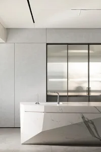 A modern kitchen with white marble countertops and sleek, minimalist design.