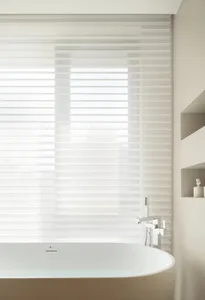 A minimalist bathroom with a transparent glass window featuring horizontal blinds, showcasing sleek design elements in a cont