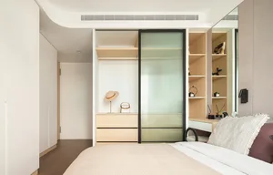 Minimalist bedroom with a single bed, a small desk, and a window with a shade.