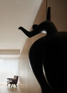 Minimalist living room featuring a black sculpture with a high contrast and geometric design.