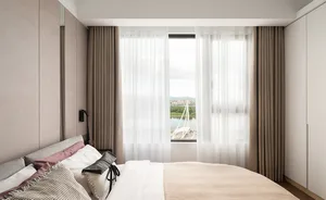 A serene bedroom featuring modern design with light-colored fabric and a glass window overlooking a scenic view.