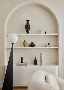 A minimalist living space featuring concrete shelving and ceramic decorations.