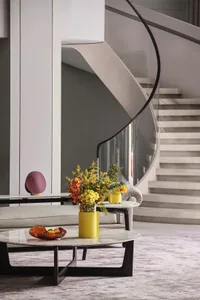 A modern living space featuring a circular marble coffee table, a comfortable sofa adorned with modern decor, and a stylish v