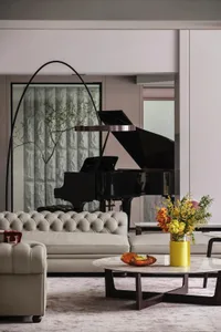 A minimalist living room with leather furniture, a round marble coffee table, and a tall floor lamp.
