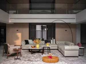 A modern living room with neutral-toned furniture, large windows, and a minimalist design.