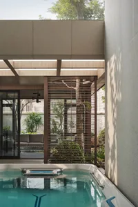 Concrete, brick, and wooden outdoor living space with a modern architectural design.