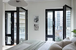 A minimalist bedroom featuring a bed with a glass top, a metal frame, and a concrete floor, adorned with polyester bedding an