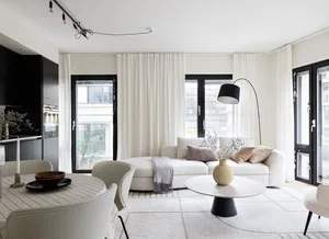 Modern, minimalist living room with white fabric couch, white interiors, and minimalist decor.