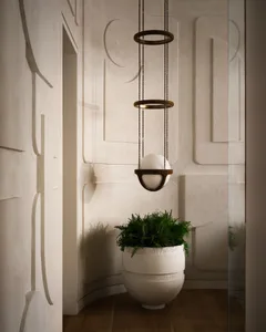 A modern bathroom features concrete planters and a decorative lighting fixture.