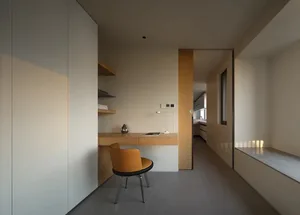 A minimalist home office with a wooden desk and a yellow chair.