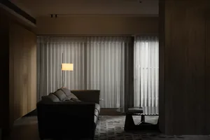 Modern minimalist living room with white curtains on a large window.