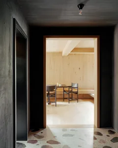 Industrial-style restaurant interior with wooden flooring and seating area.