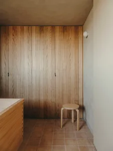 A minimalist bedroom featuring wooden paneling.