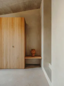 Minimalist corner shelf with a wooden shelf and a concrete wall.