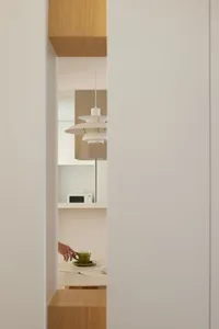 A minimalist kitchen with white cabinets and a countertop.