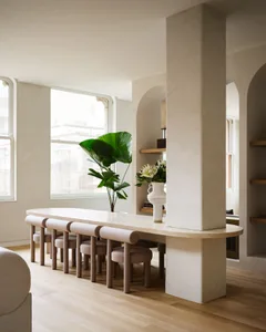 Modern minimalist living room with concrete elements and wooden flooring.