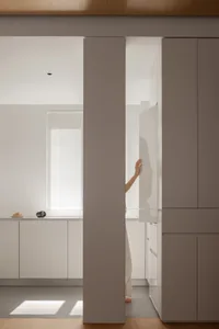 A modern minimalist kitchen features white cabinets and a clean, uncluttered design, showcasing sleek and stylish aesthetics 