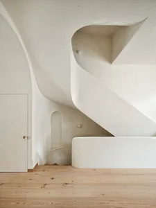 Modern minimalist concrete staircase with curved walls and no visible steps.