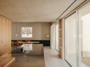Modern minimalist kitchen with concrete surfaces and a sleek, open design.