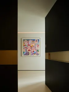 A modern minimalist interior design featuring a contemporary art piece depicting multiple figures.