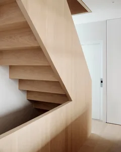 Modern floating staircase with wooden steps and railings.