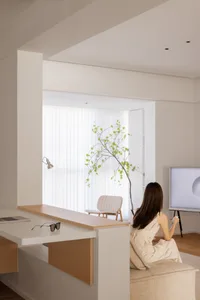A modern living room with neutral-toned furniture and decor, featuring a minimalistic design and natural light.
