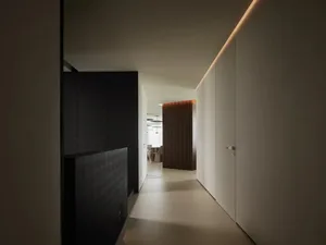 A minimalist modern corridor with white walls and hidden lighting.