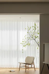 A clean, modern interior design featuring vertical fabric blinds and a minimalist armchair.