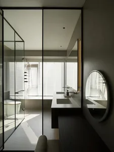 Modern minimalist bathroom featuring glass walls and white ceramic fixtures.