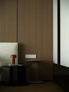 Contemporary bedroom with wooden paneling, fabric headboard, and metal side table.