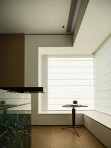 Modern minimalist interior featuring marble countertops, wooden flooring, and glass elements.