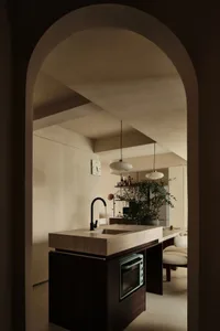 Modern kitchen with concrete countertops and black faucet.