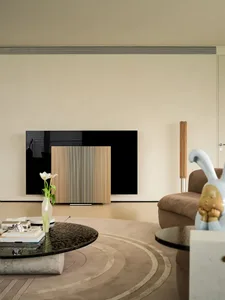 A modern living room with marble flooring, a wooden cabinet, and a sleek black TV.