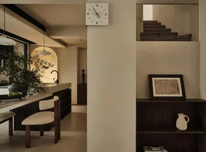 Modern residential kitchen featuring concrete walls, wooden furniture, and leather accents