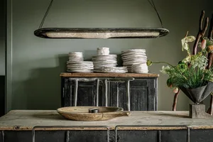 A rustic kitchen with industrial elements, featuring ceramic plates and a wooden countertop.