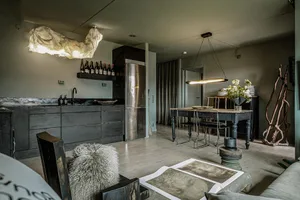 An industrial-style living room with metal furniture, concrete flooring, and wooden accents.