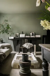 A modern industrial living room featuring rustic wooden furniture, stone accents, and metal elements.