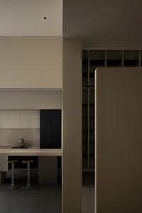 A minimalist kitchen with concrete countertops and minimalist cabinets.