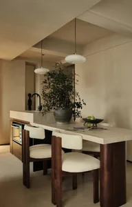 A minimalist kitchen with a white marble countertop and wooden furniture.