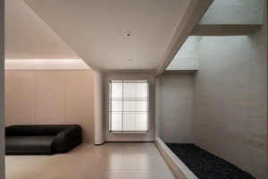 Minimalist living space featuring concrete walls and large glass windows.